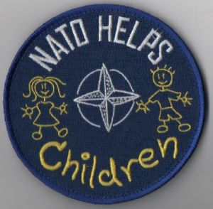 Image not found :NATO HELPS CHILDREN (NATO STAR/MEISJE/JONGEN FIGUUR) (BLAUW/GEEL/WI